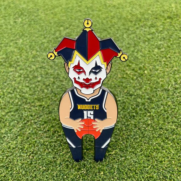 Pin Creatures' "Joker" is a cartoon pin of a Denver Nuggets player in jersey 15 with a jester mask, standing on green grass. It features a built-in golf ball marker and a magnetic hat clip, adding extra fun to your golf game.