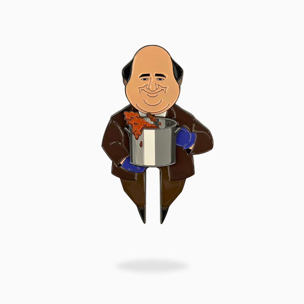 The Chili Cook Off Divot Tool by Pin Creatures is a fun golf accessory featuring a cartoon bald man in a brown suit with blue gloves holding a pot of orange chili—an eye-catching ball marker for your next round.