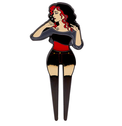 The Bunkers & Rough NSFW Lady Surprise Divot Tool features a wavy-haired woman in black and red, appearing thoughtful. Its lower prongs double as a functional and stylish golf accessory.