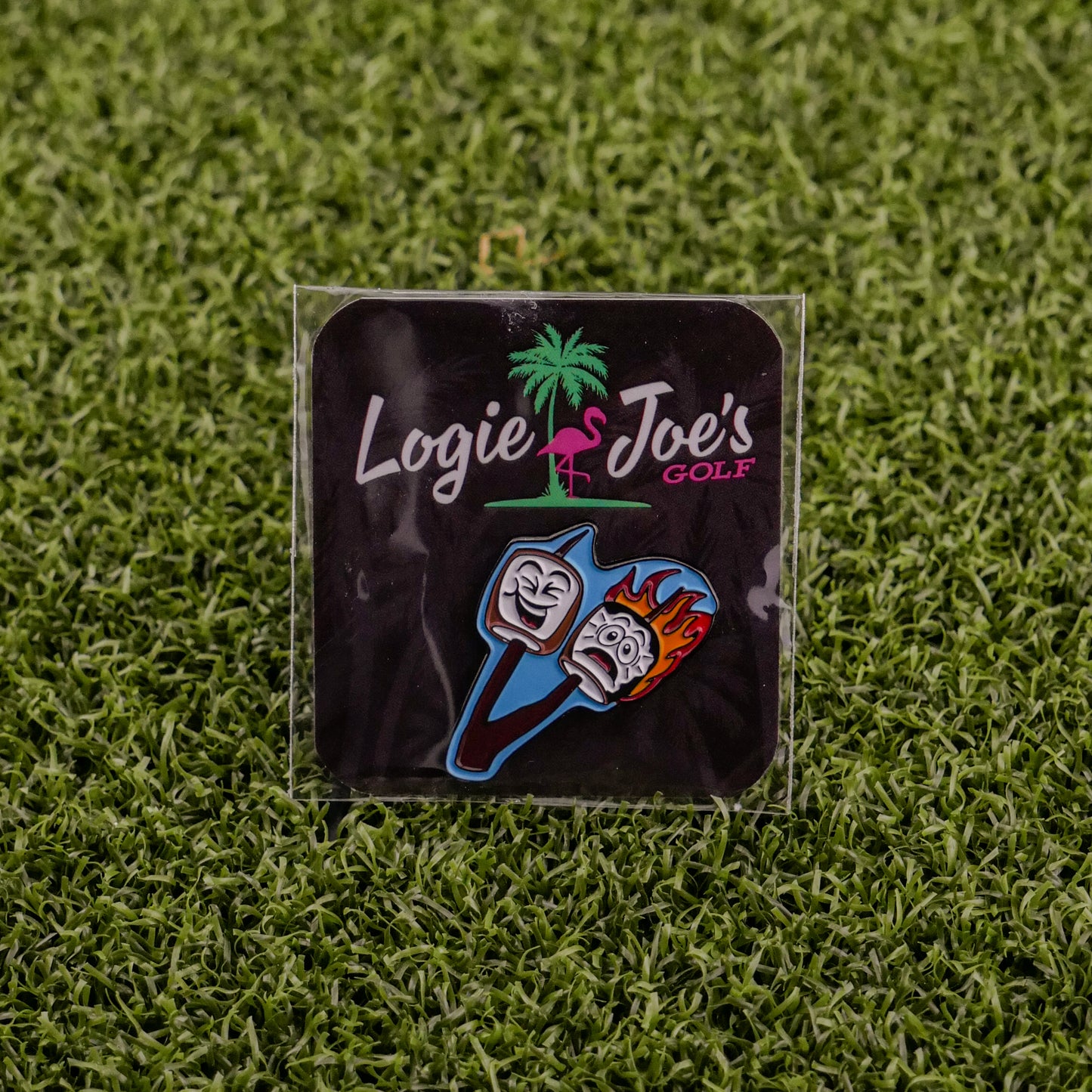 Logie Joe’s Golf Marshmallows feature two cartoon golf tees—one calm, one surprised and flaming—on a grass background. The playful packaging is decorated with a palm tree and a pink flamingo for fun on and off the course.