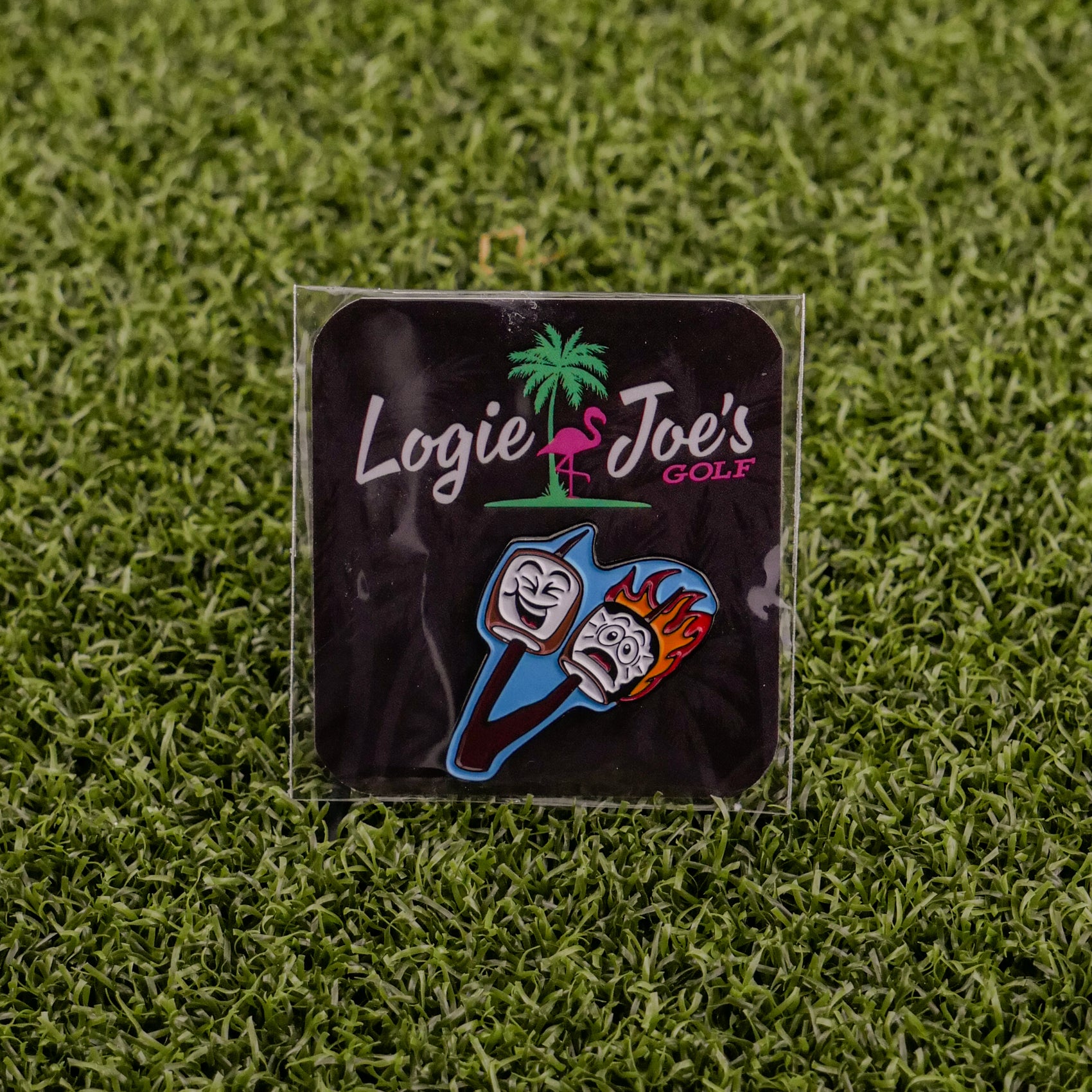Logie Joe’s Golf Marshmallows feature two cartoon golf tees—one calm, one surprised and flaming—on a grass background. The playful packaging is decorated with a palm tree and a pink flamingo for fun on and off the course.