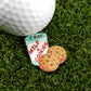 The Logie Joe's Golf "Milf & Cookies" golf ball marker features a milk glass-shaped pin labeled “I EAT MILK & COOKIES,” two chocolate chip cookies, and a premium golf ball, making it a fun addition to any collection.