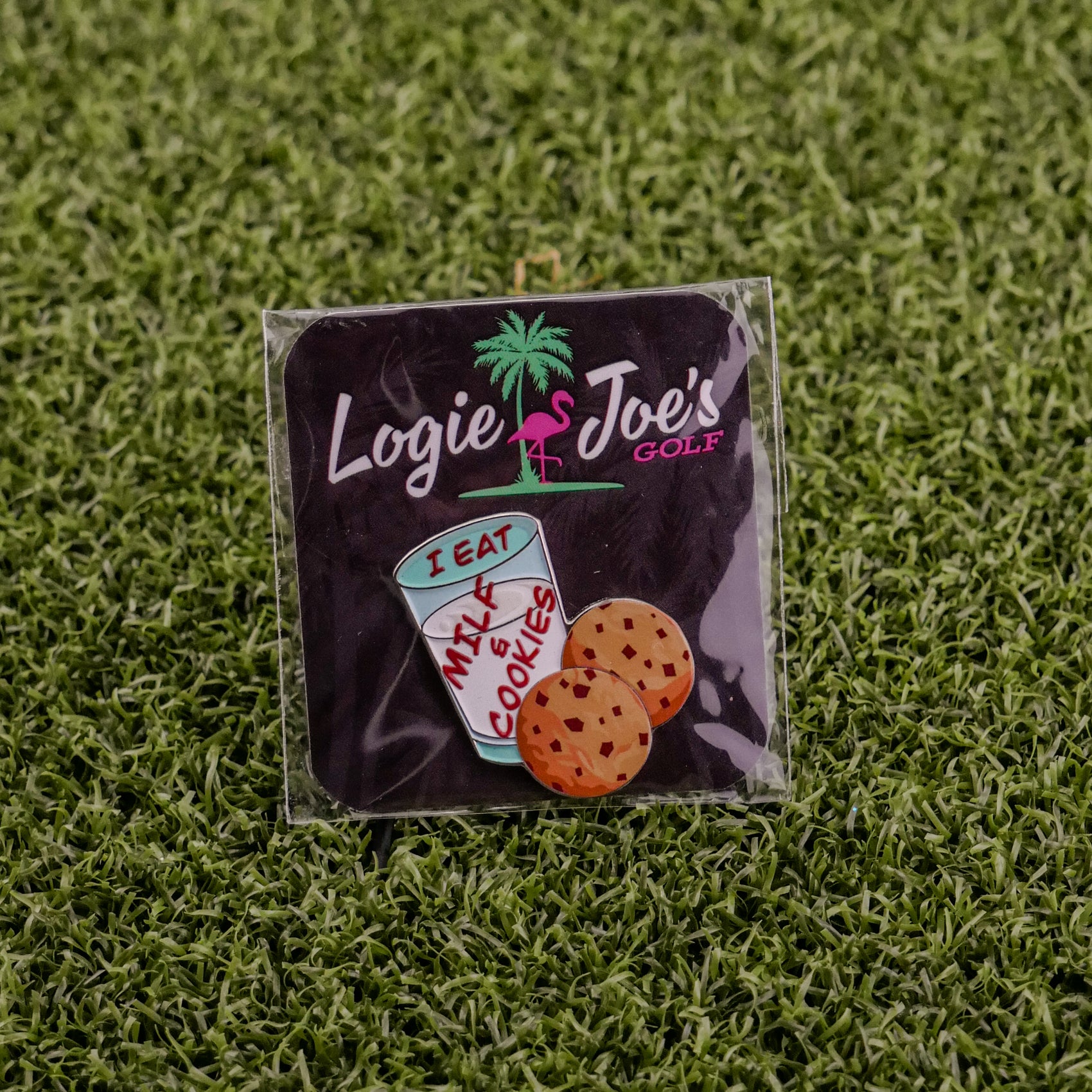 A square pin by Logie Joe's Golf features a cartoon milk cup labeled "Milf & Cookies" next to two chocolate chip cookies—perfect as a premium-quality golf ball marker for the course.