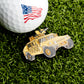 A close-up of the Humvee Ball Marker by Ballmarkers.com, featuring an American flag on a golf ball beside a yellow toy military vehicle on green grass, brings bold tactical style to your game.
