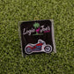 A red and silver Motorcycle ball marker pin by Logie Joe’s Golf, presented on a black card with colorful branding and set on green artificial grass—a standout addition to premium golf accessories.