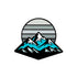 A stylized illustration of blue and black mountains with snowy caps against a striped backdrop—Logie Joe’s Golf Mountain Moonrise Ball Marker is the perfect unique golf accessory.