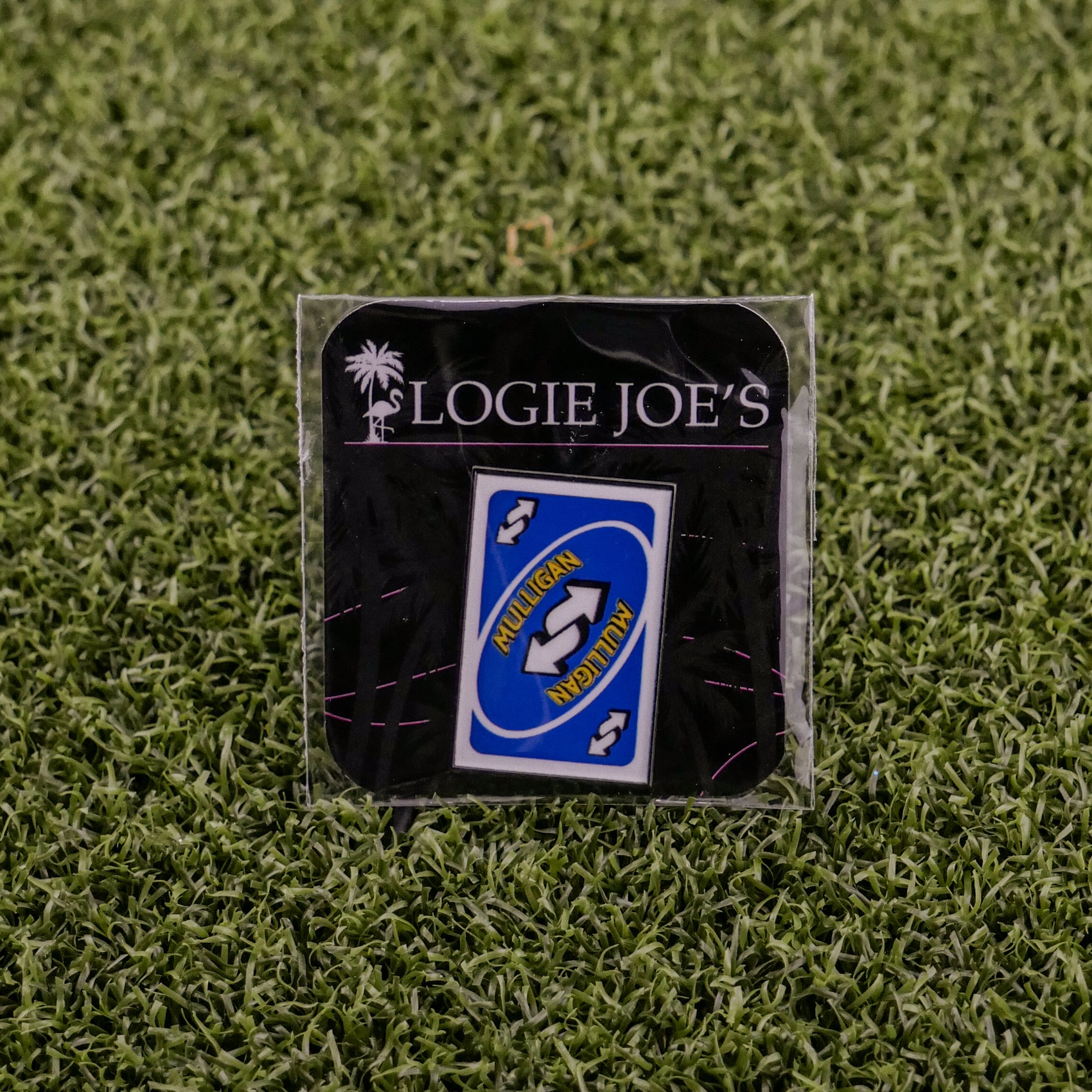 A Mulligan Reverse Card Blue pin by Logie Joe’s Golf is shown in packaging on grass. Ideal for premium golf accessory fans, the pin features NEILLIGAN, NEAPITAN, and reverse arrows.