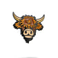 The Highland Cow Ball Marker by Pins and Aces is a cast metal and enamel marker featuring a stylized highland cow head with shaggy orange and brown fur, large curved horns, and a beige snout on a white background.