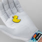 A person wearing a white golf glove with a colorful, geometric wristband holds the Pins and Aces Rubber Ducky Ball Marker in their palm.