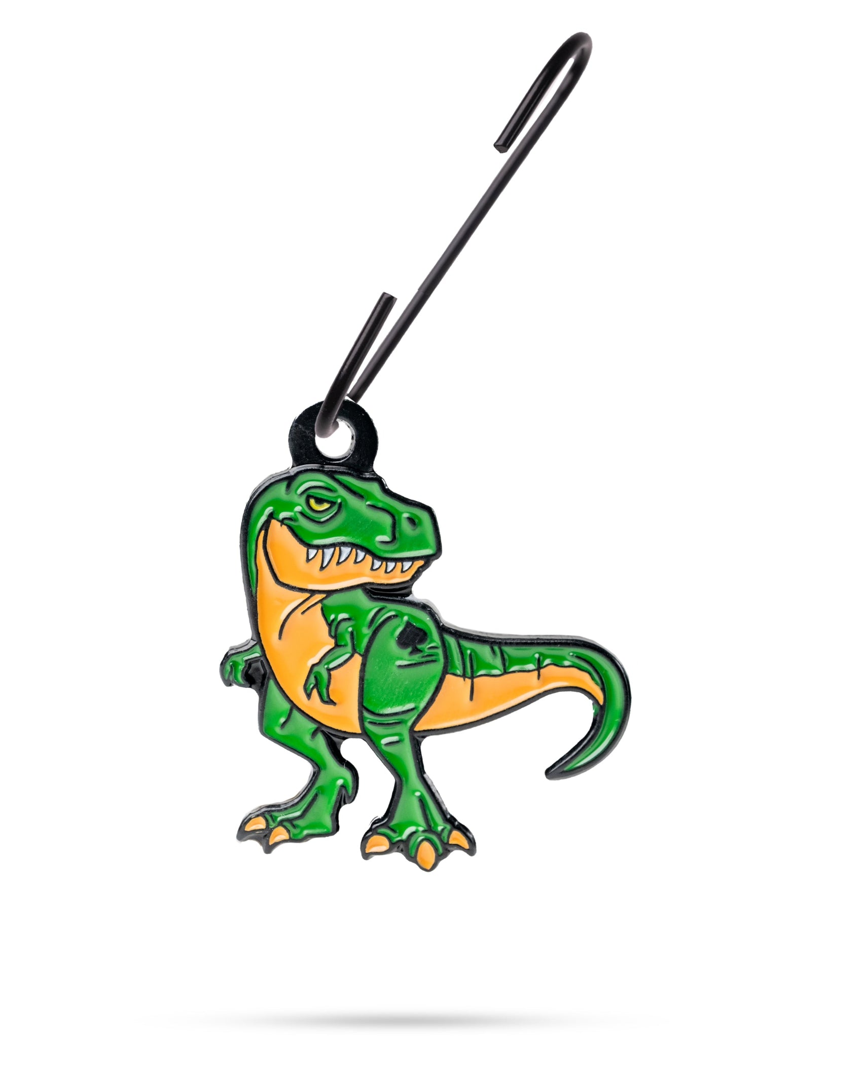 The Pins and Aces T-Rex Ornament is a green and orange cartoon dinosaur keychain, perfect for your golf bag as a fun Christmas accessory, shown hanging from a black hook against a white background.