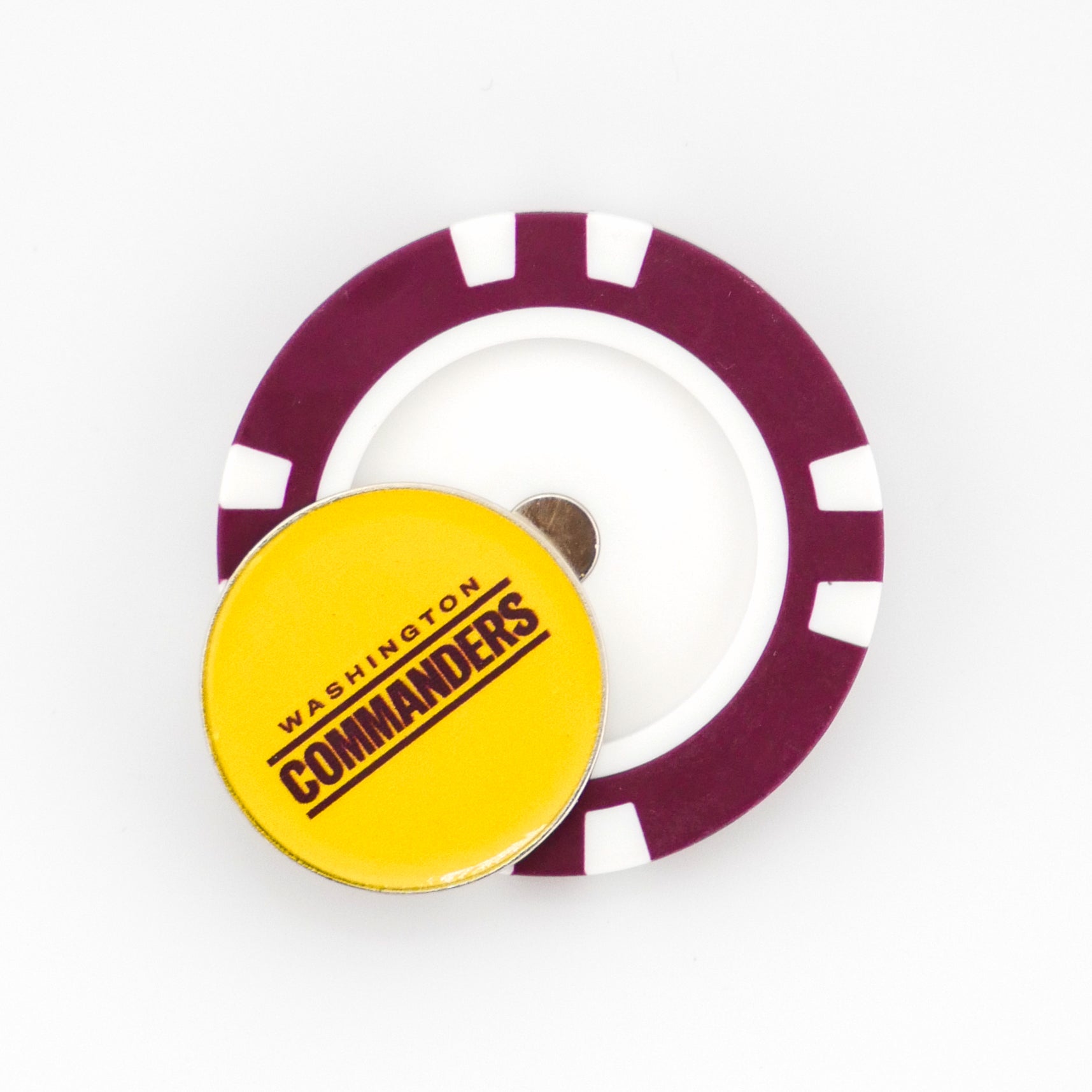 A Ballmarkers.com Washington Commanders poker chip-style marker is placed on a purple and white poker chip, both set against a white background.