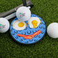 Logie Joe's Golf Breakfast Ball Putting Disk: a fun golf practice set with a putting green, three balls, a putter, and a disk cover featuring two sunny-side-up eggs and bacon as a smiling face.