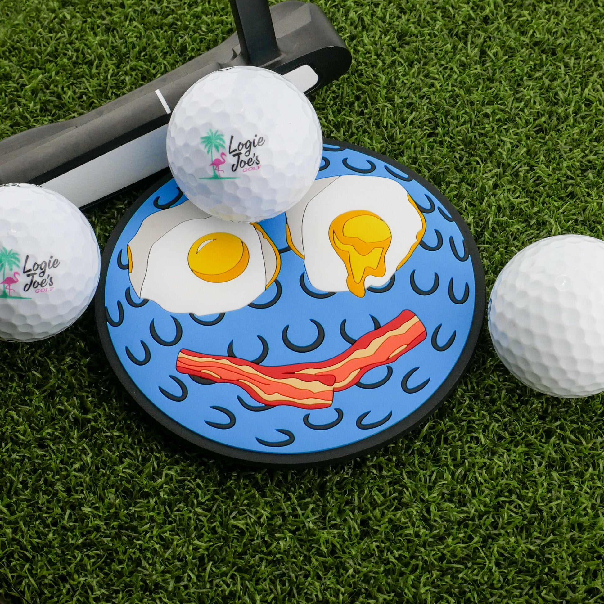 Logie Joe's Golf Breakfast Ball Putting Disk: a fun golf practice set with a putting green, three balls, a putter, and a disk cover featuring two sunny-side-up eggs and bacon as a smiling face.