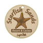 The Starfish Sands Putting Disk by Logie Joe's Golf is a round beige disk featuring a brown starfish and “Starfish Sands Resort & Casino,” with "Logie Joe’s" at the bottom. Ideal for improving putting accuracy, it has a small hole at the top for easy attachment.