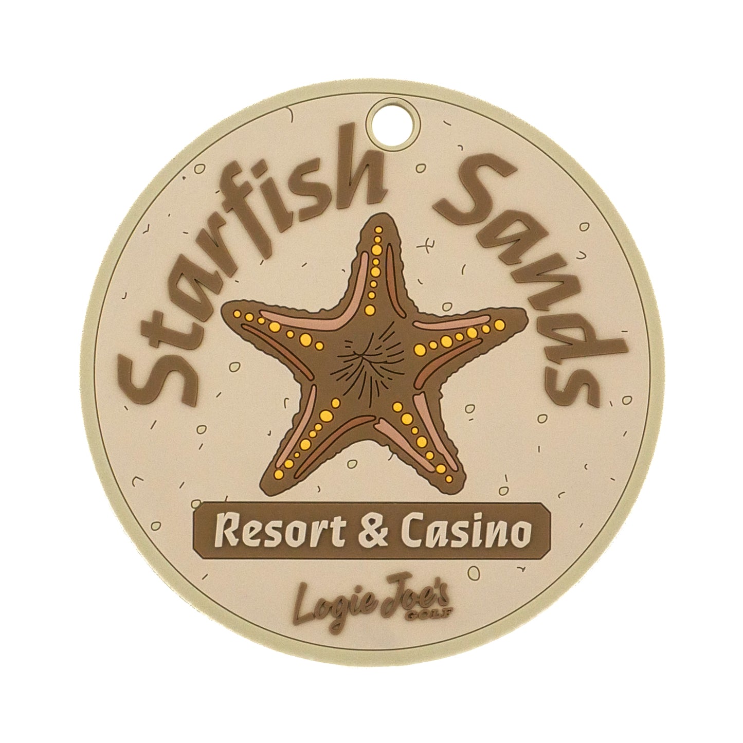 The Starfish Sands Putting Disk by Logie Joe's Golf is a round beige disk featuring a brown starfish and “Starfish Sands Resort & Casino,” with "Logie Joe’s" at the bottom. Ideal for improving putting accuracy, it has a small hole at the top for easy attachment.