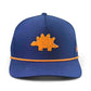 The Logie Joe's Golf Dino Nugget Snapback Hat + Matching Ball Marker is a blue hat with an orange stegosaurus patch on the front and orange trim along the brim.