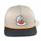 The Logie Joe's Golf Breakfast Ball Snapback Hat + Matching Ball Marker is a beige and black cap with orange trim, featuring an embroidered cracked golf ball that looks like a fried egg and includes a built-in magnet for the marker.