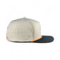 The Logie Joe's Golf Breakfast Ball Snapback Hat features a beige design with small ventilation holes, an orange-accented visor edge, black bill, subtle horseshoe logo, and a built-in magnet with a matching ball marker.