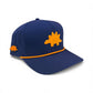 The Logie Joe's Golf Dino Nugget Snapback Hat + Matching Ball Marker features a navy blue design with an orange stegosaurus patch on the front, a smaller stegosaurus on the side, perforated side panels, and orange trim above the brim.