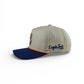 The Tiki Bear Golf Hat by Logie Joe's Golf is a beige and navy snapback cap with orange trim, front patch logo, side embroidery, built-in magnetic ball marker holder, and included marker. Shown on a white background.