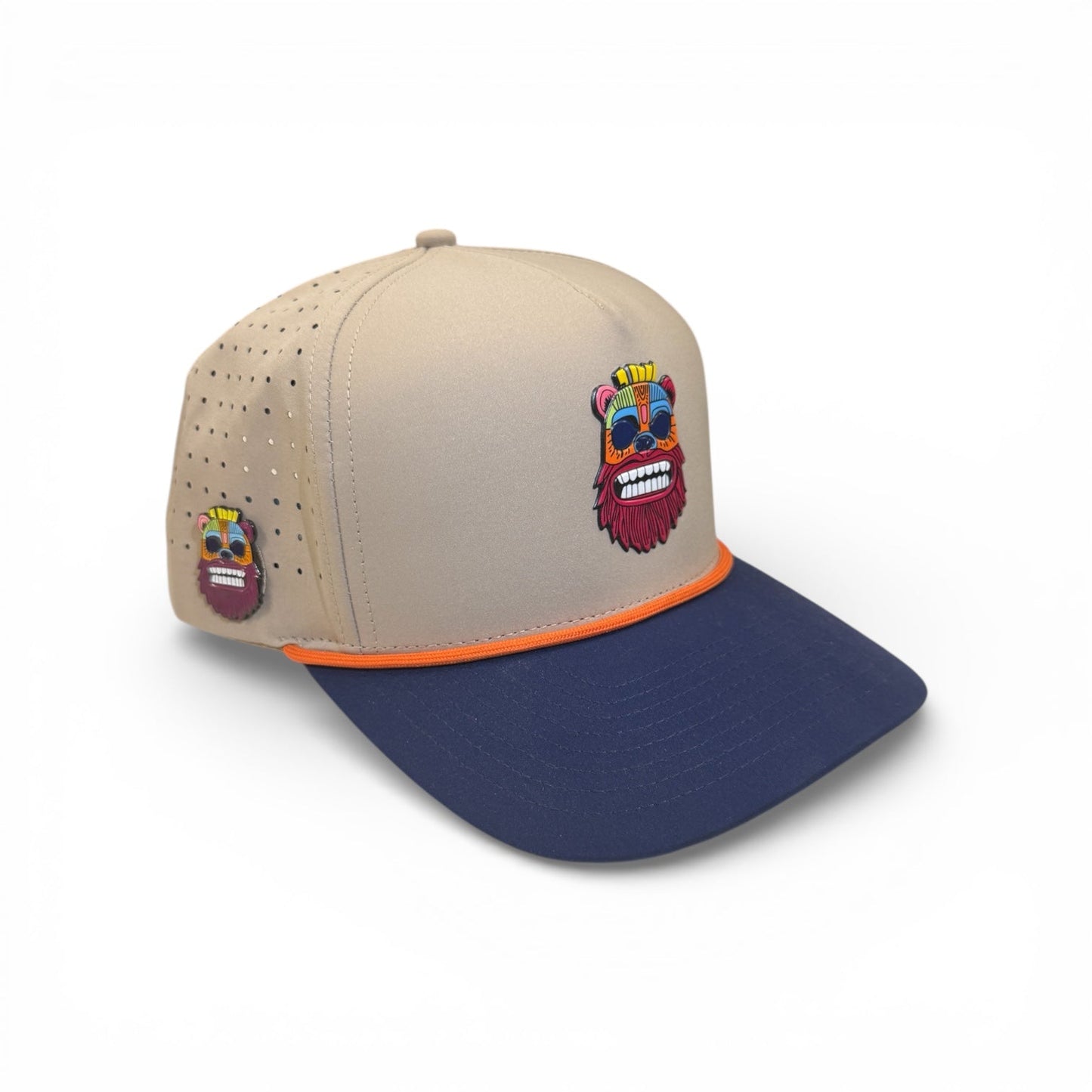 The Logie Joe's Golf Tiki Bear Golf Hat is an adjustable snapback cap with a multicolor cartoon bear patch, orange trim, side ventilation holes, and a built-in magnet holder plus included ball marker.
