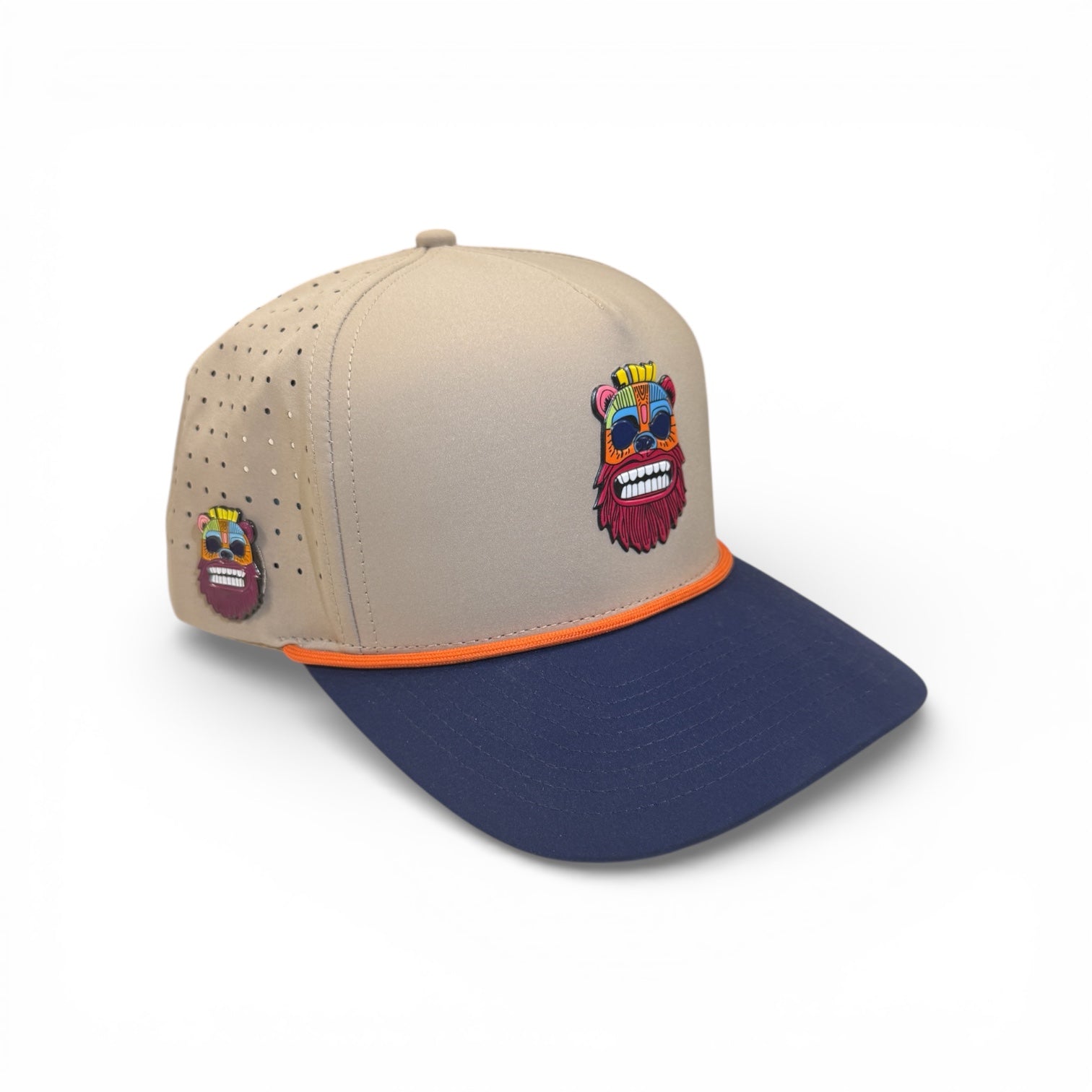 The Logie Joe's Golf Tiki Bear Golf Hat is an adjustable snapback cap with a multicolor cartoon bear patch, orange trim, side ventilation holes, and a built-in magnet holder plus included ball marker.