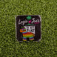 The I’d Hit That Piñata pin by Logie Joe’s Golf features a colorful piñata design with “ID HIT THAT,” displayed on artificial grass. Its backing card shows the Logie Joe’s Golf name with a palm tree and flamingo graphic. Perfect for golf accessory fans.