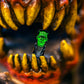 A Pins and Aces Frankenstein Ball Marker is gripped between the sharp yellow teeth of a fierce, red-mouthed creature with large fangs, creating a dramatic scene emphasized by the blurred background—an eye-catching golf accessory in action.