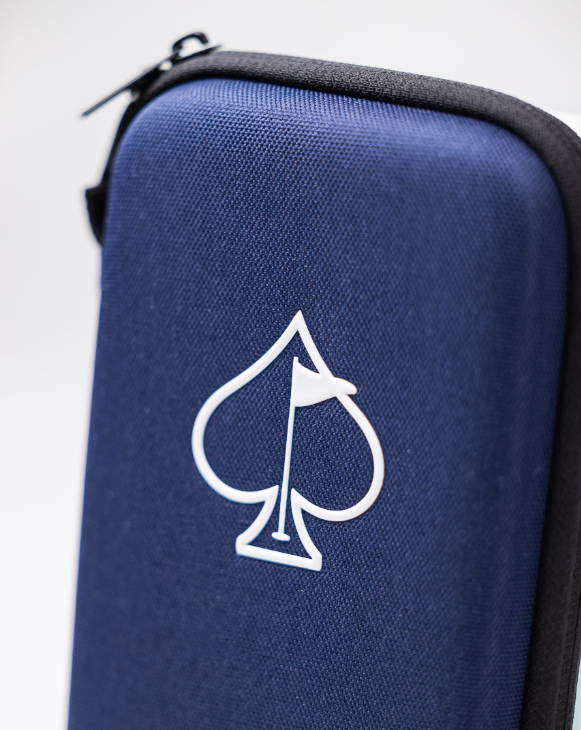 A close-up of the Pins and Aces Glove & Accessory Caddie - Navy, a zippered golf gear organizer featuring a white spade with a flag in the center, set against a plain light background.