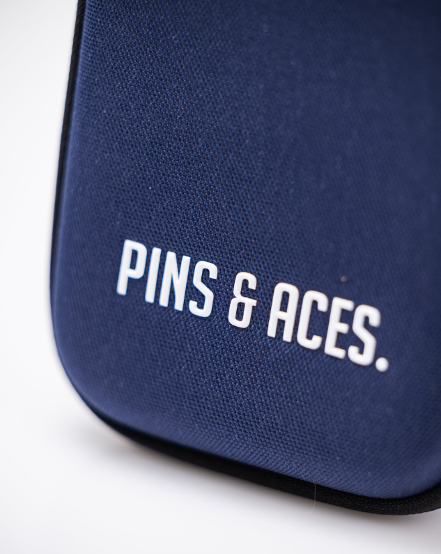 A close-up of the Glove & Accessory Caddie - Navy by Pins and Aces, featuring bold white branding on the front—a stylish accessory caddy for your golf essentials.