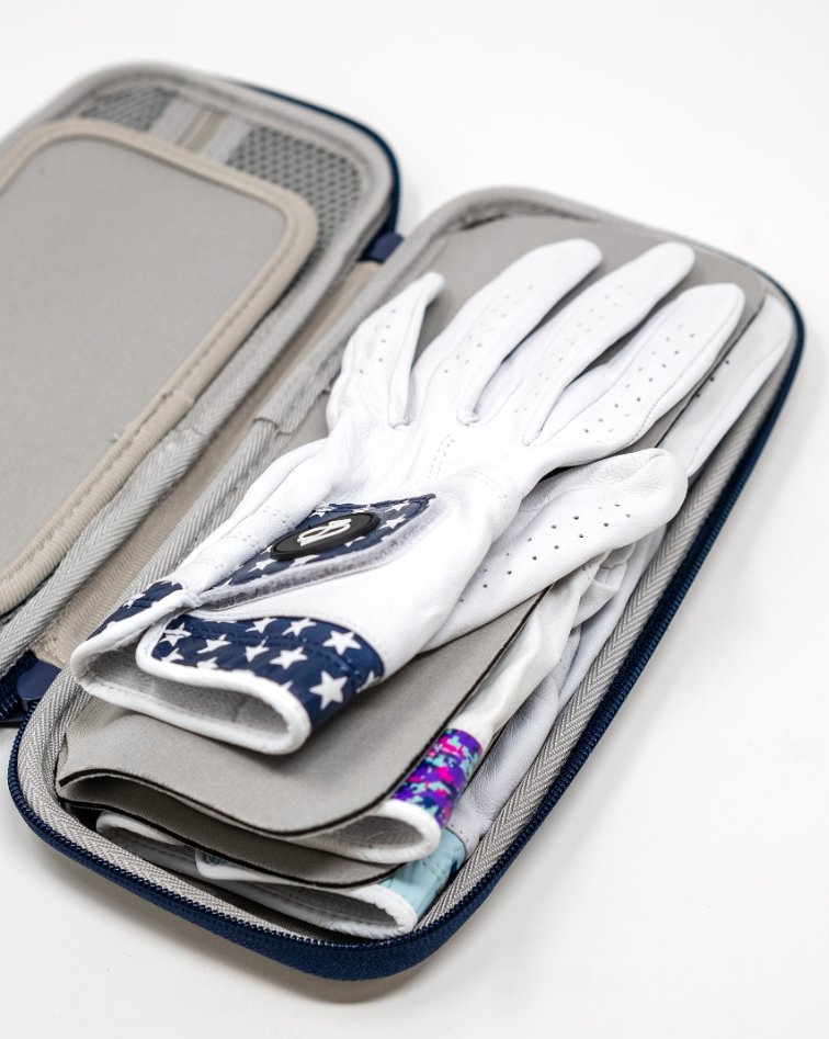 The Pins and Aces Glove & Accessory Caddie - Navy holds several white golf gloves, with one glove on top featuring a dark blue star pattern on the wrist.
