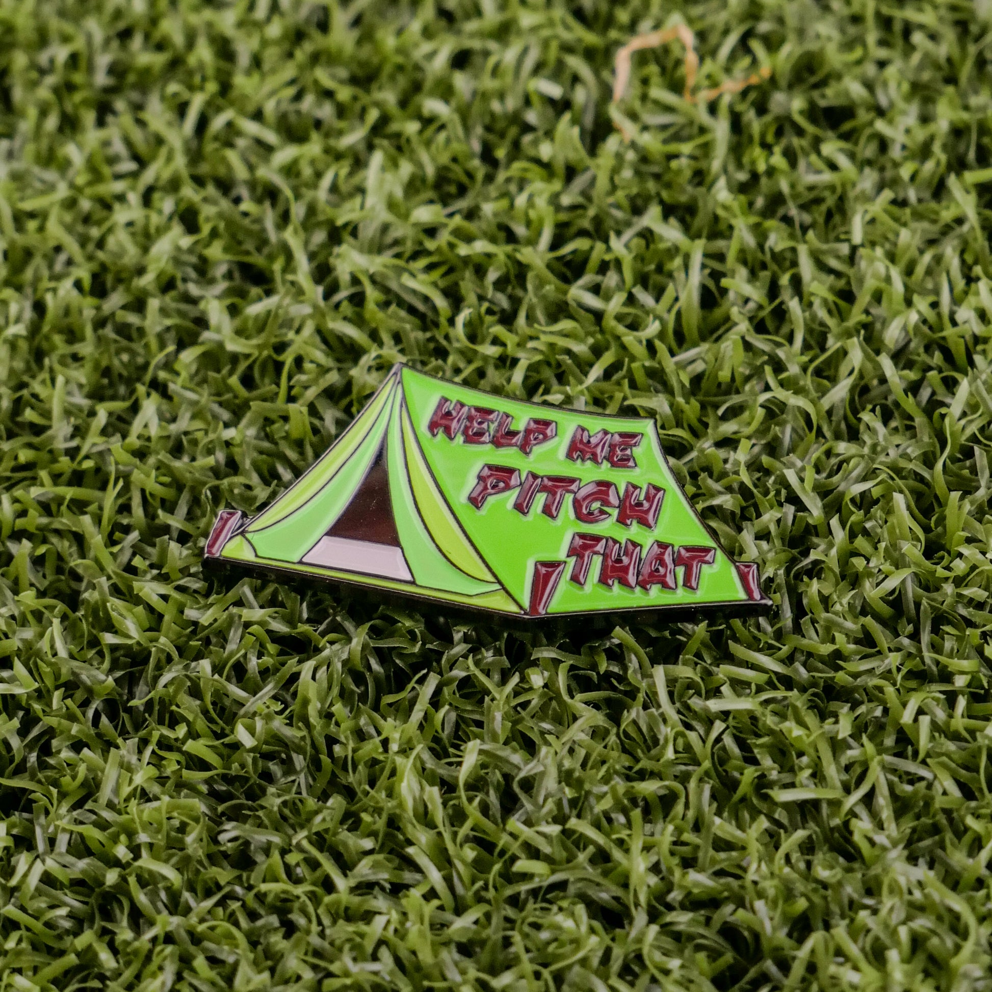 Introducing Pitch That Tent by Logie Joe's Golf—a green tent-shaped ball marker on grass with “HELP ME PITCH THAT” in bold pink and white, perfect for standing out among your premium golf accessories.