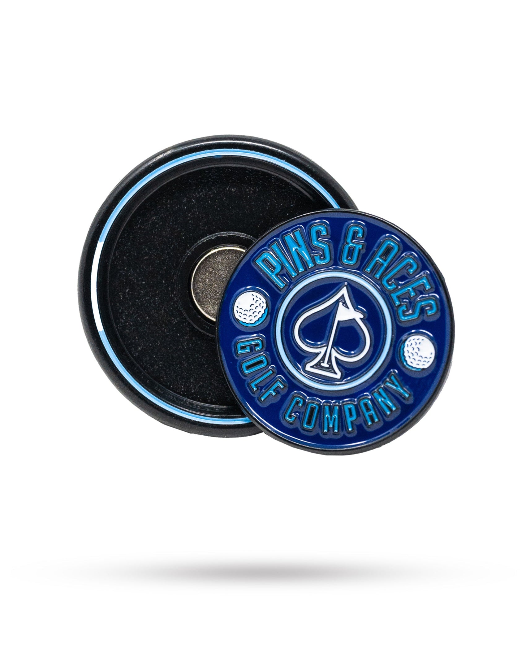 A thin, navy Pop Out Medallion Ball Marker by Pins and Aces, featuring "PINS & ACES GOLF COMPANY" and golf ball designs, shown next to its circular holder.