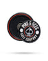 The Pop Out Medallion Ball Marker - Black by Pins and Aces is a round black and silver magnetic marker with brand text and spade symbol, stored in a matching black circular case with red trim.