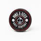 The Pop Out Medallion Ball Marker - Black by Pins and Aces is a thin, black circular marker with red and silver accents, featuring the brand name around a spade symbol and two golf balls.