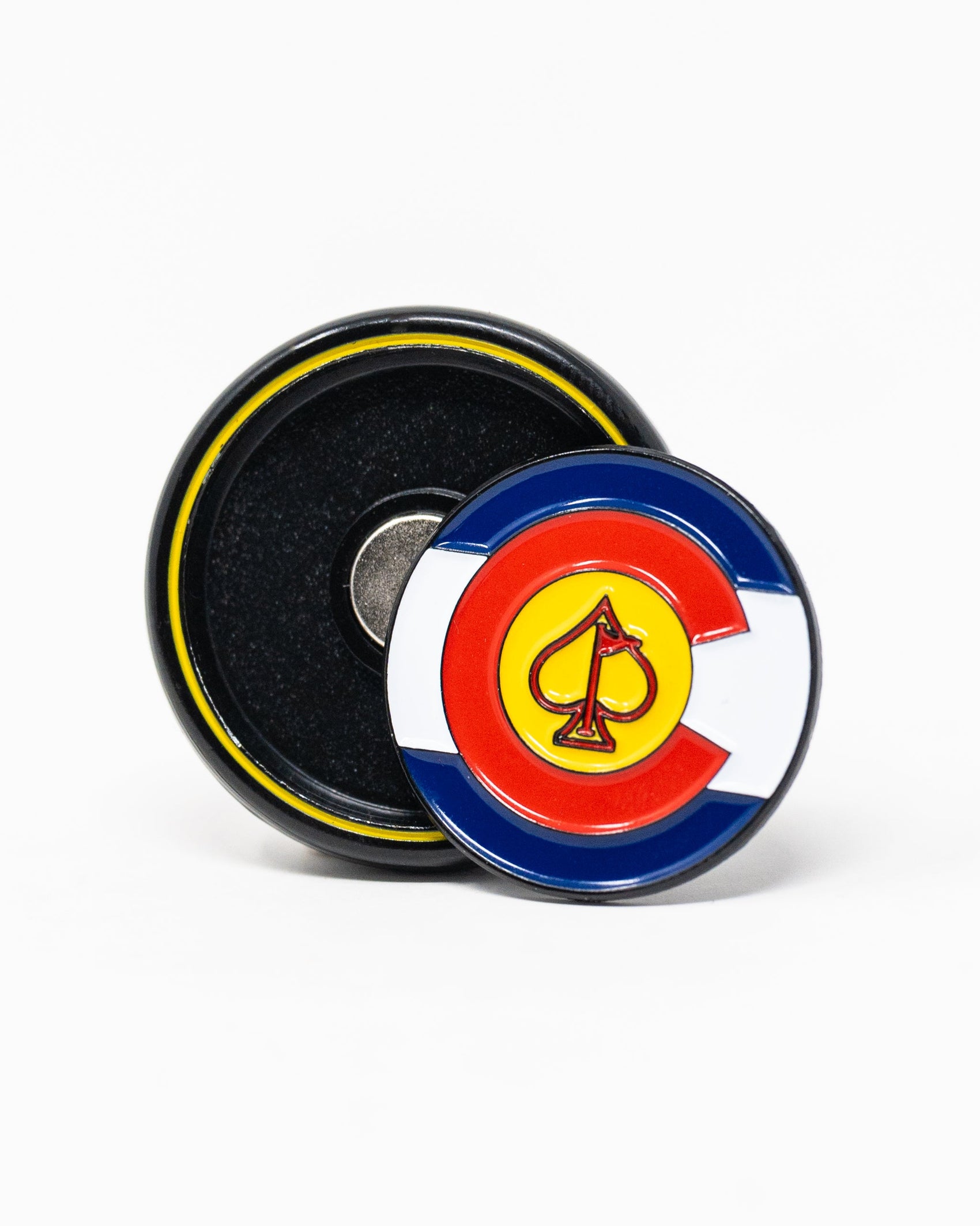 The Pop Out Medallion Ball Marker - Colorado by Pins and Aces is a round enamel pin with the Colorado state flag and yellow spade, designed as a magnetic ball marker, shown leaning against its black and yellow backing on a white background.
