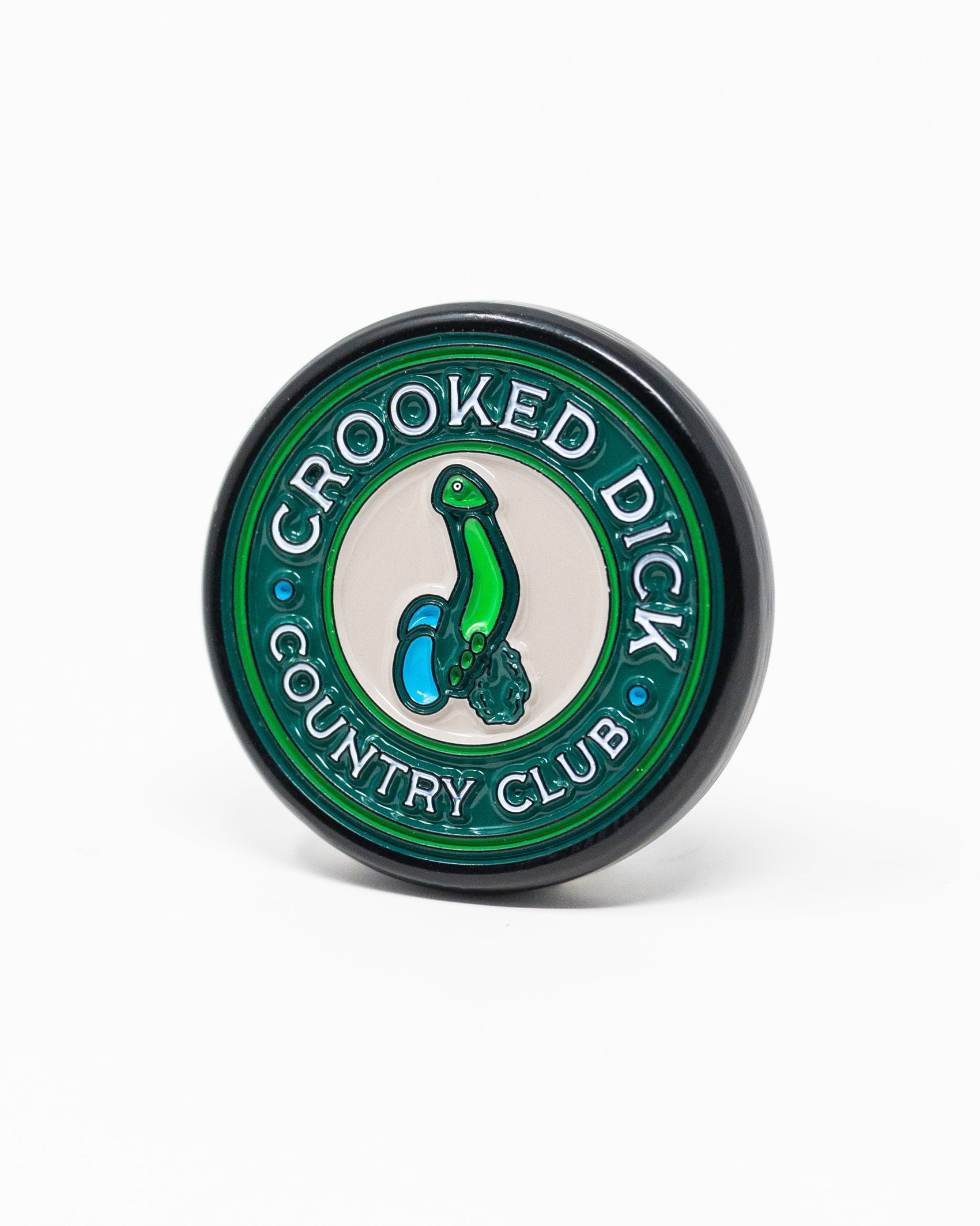 The Pop Out Medallion Ball Marker - Crooked Dick by Pins and Aces is a round green and black marker with "CROOKED DICK COUNTRY CLUB" around the edge, a cartoon snake in the center, and a convenient pop-out design.