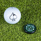 The Pop Out Medallion Ball Marker - Green by Pins and Aces features a magnetic ball marker with a black spade symbol, resting on bright green artificial grass—the ideal golf accessory for your next round.