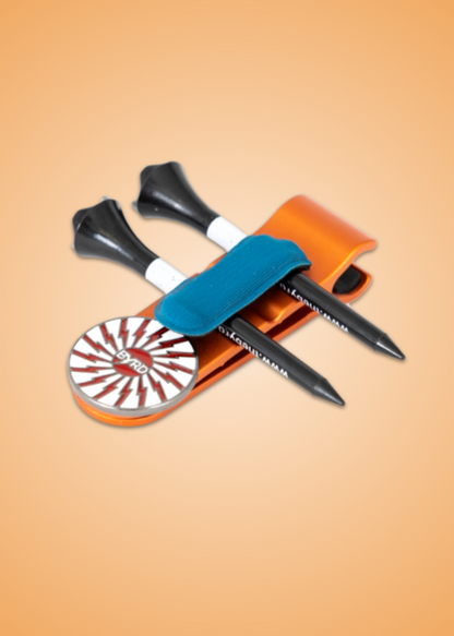 Two black golf tees and a striped round ball marker rest on the orange THE BYRD GOLF CLYP - Orange Oriole by The Byrd, LLC, secured with a blue strap. The gradient orange backdrop is perfect for organizing your golf accessories in style.