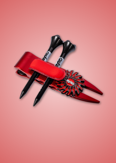 THE BYRD GOLF DIVOT CLYP by The Byrd, LLC—organize your golf gear in style! Sleek black and white tool held in a shiny red holder with a circular design, set against a pink gradient. HOT PRODUCT—order now before it sells out!.