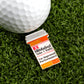 A golf ball rests on green grass beside a Ballmarkers.com premium marker shaped like a prescription bottle labeled RX Hitdabol.