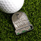 The Rest In Par Ball Marker by Ballmarkers.com is a metal tombstone-shaped golf accessory featuring a golf flag design and the words "Rest in Par," shown on green artificial grass beside a white golf ball.