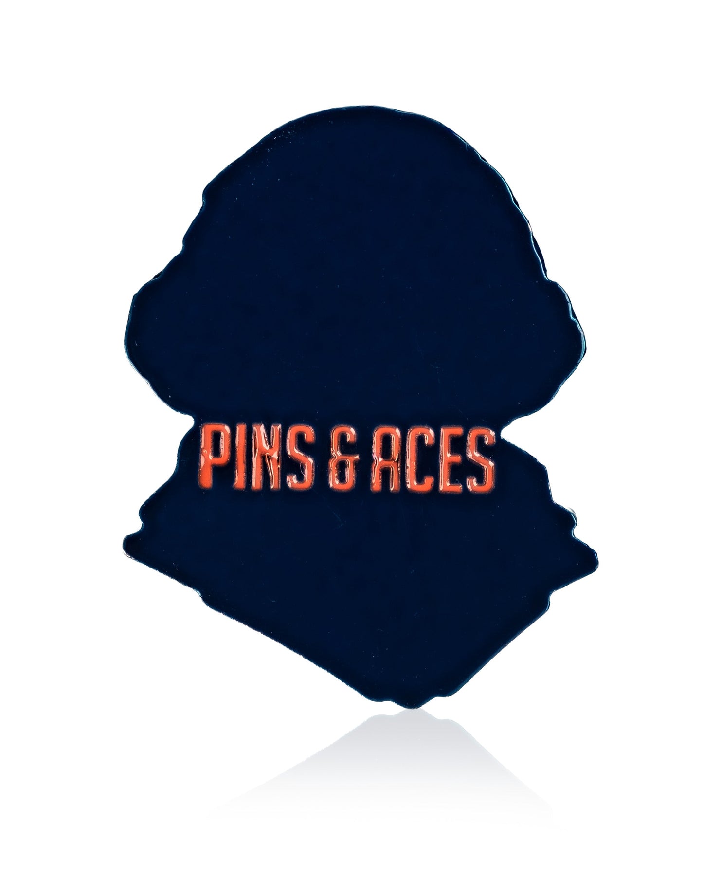 The Rockin Washington - Ball Marker by Pins and Aces is a dark, silhouette-shaped golf accessory featuring bold orange branding. It functions as both a magnetic hat clip and ball marker, shown on a white background.