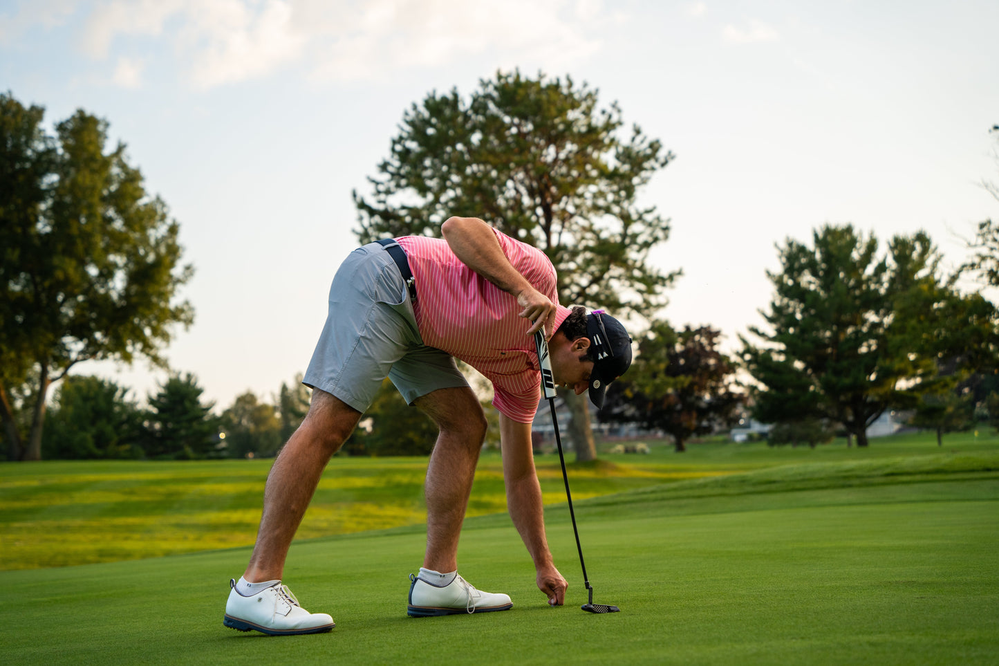 A man holding THE BYRD GOLF DIVOT CLYP by The Byrd, LLC—the only golf tool that organizes gear. Hurry, it's in low stock!.