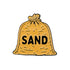 The Sandbagger Ball Marker by Ballmarkers.com features a yellow-brown sack labeled SAND in bold black letters, tied at the top, with small black dots to represent sand grains.