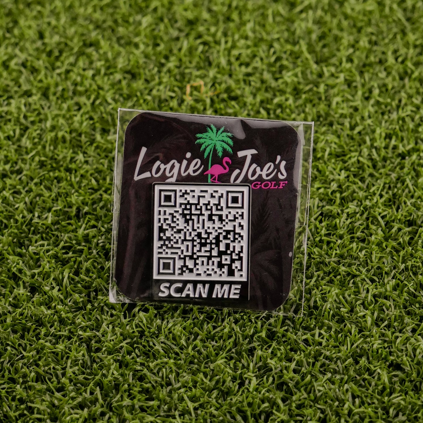 The Scan Me square sticker by Logie Joe's Golf features a QR code, “Logie Joe’s Golf” text above a pink flamingo and palm tree graphic, and “SCAN ME” below—a fun accessory for golf fans seeking premium markers.