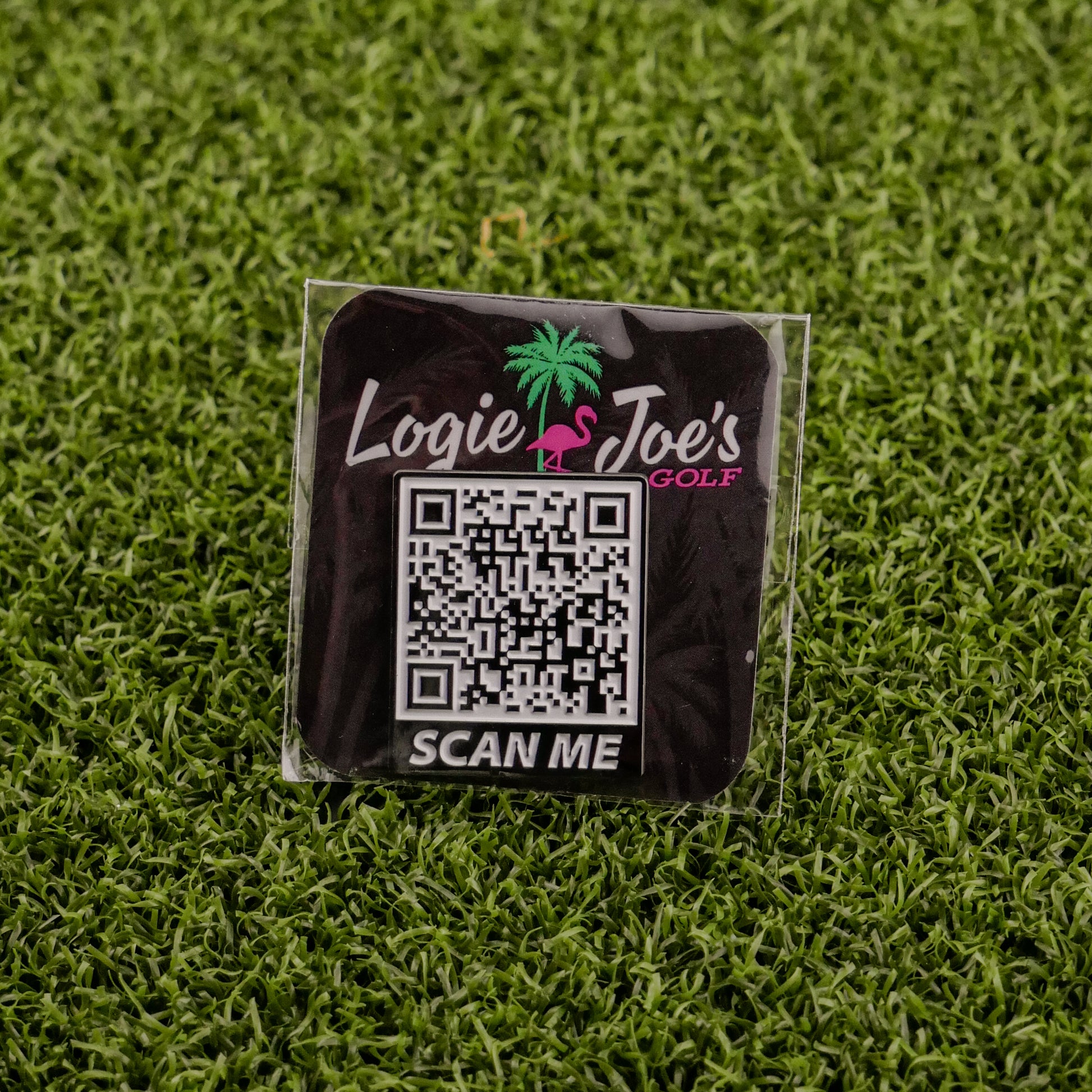 The Scan Me square sticker by Logie Joe's Golf features a QR code, “Logie Joe’s Golf” text above a pink flamingo and palm tree graphic, and “SCAN ME” below—a fun accessory for golf fans seeking premium markers.