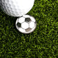 A close-up of a golf ball on artificial green grass with the Ballmarkers.com Soccer Ball Ball Marker emphasizes the precision needed in your short game.