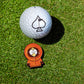 A South Park Ball Marker - Kenny by Pins and Aces, featuring a golf ball with a black spade symbol beside a Kenny figurine in an orange parka, perfect for fans and collectors.