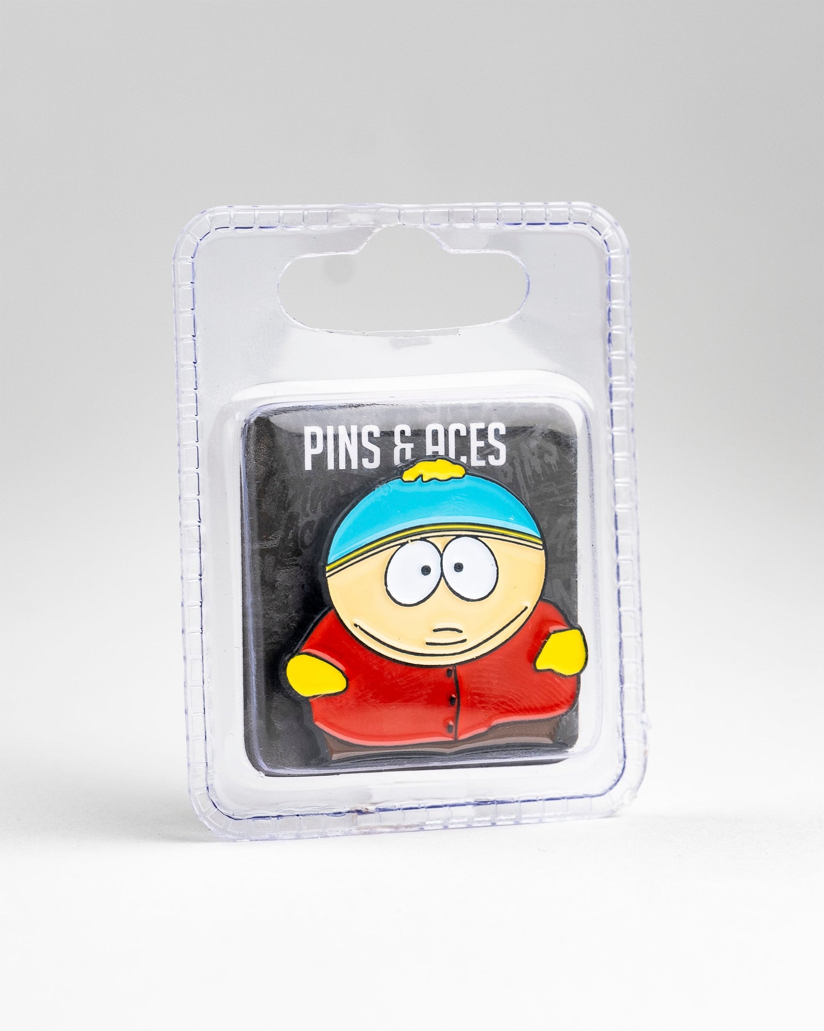 The South Park Ball Marker - Cartman by Pins and Aces features Eric Cartman's iconic look, packaged in clear plastic—ideal for South Park golf fans or collectors of premium golf accessories.
